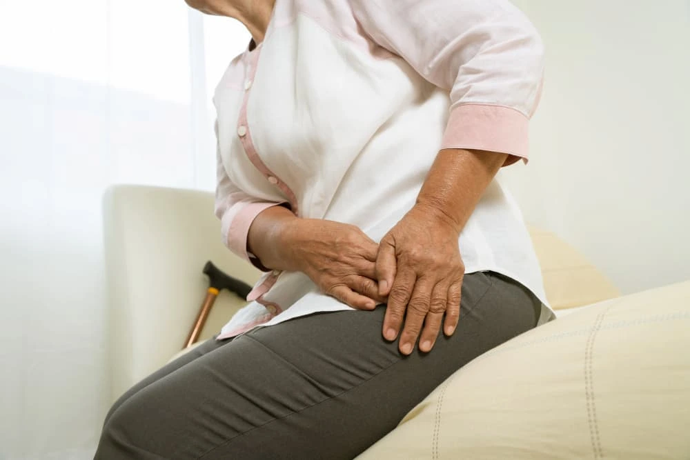 Pain management in 3071 Perry Ave, Bronx, NY 10467 — an elderly woman holding her hip in discomfort, illustrating the need for personalized treatment to relieve chronic or joint pain.