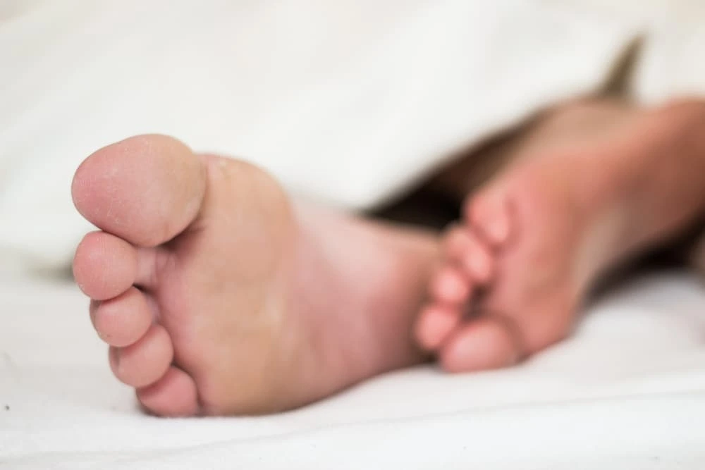 Podiatrist in 3071 Perry Ave, Bronx, NY 10467 — close-up of feet resting under a blanket, representing specialized foot care, pain relief and podiatric treatment.